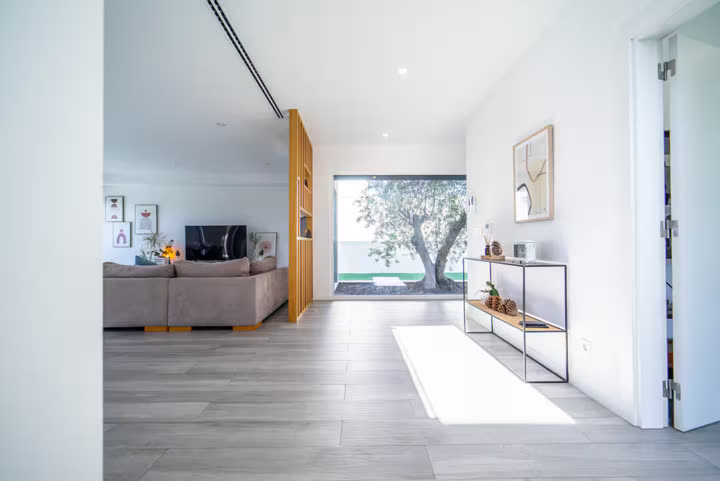 Interior de uma moradia com sala ampla e pavimento em madeira